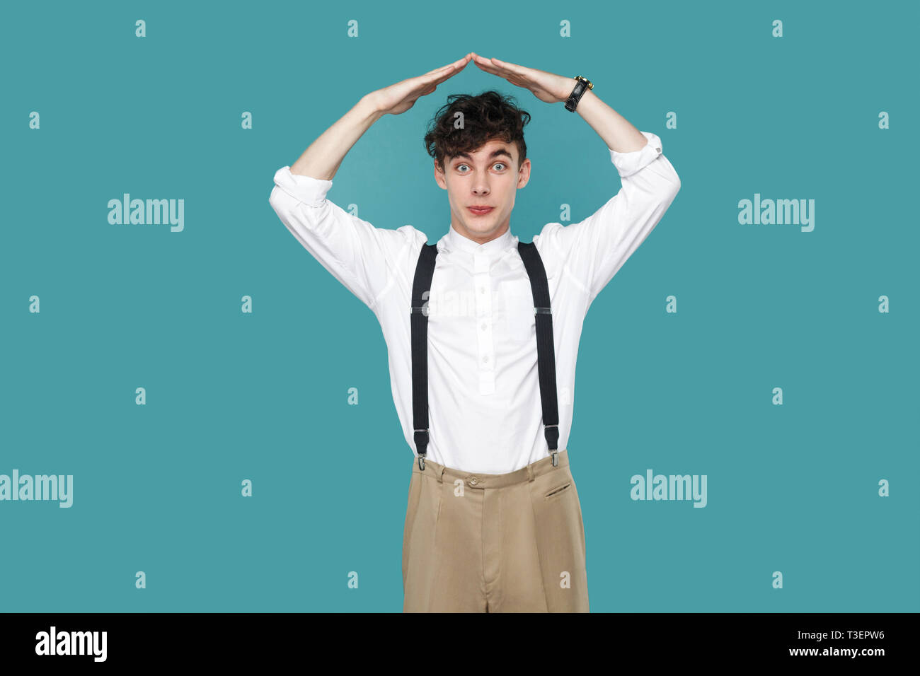Mann mit home Dach Handzeichen Geste auf Kamera. Portrait von Stattlichen hipster lockige Junge Unternehmer im klassischen Casual weißes Hemd, Hosenträger Stockfoto