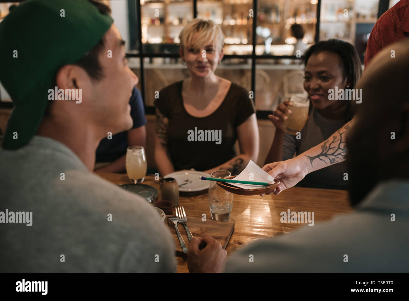 Kellner Übergabe der Rechnung an zufriedene Kunden in einer Bar Stockfoto