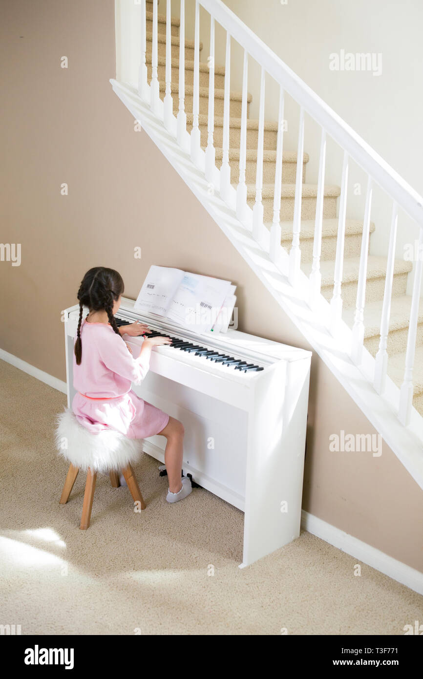 6-7 Jahre altes Mädchen ist Klavier zu Hause spielt. Stockfoto