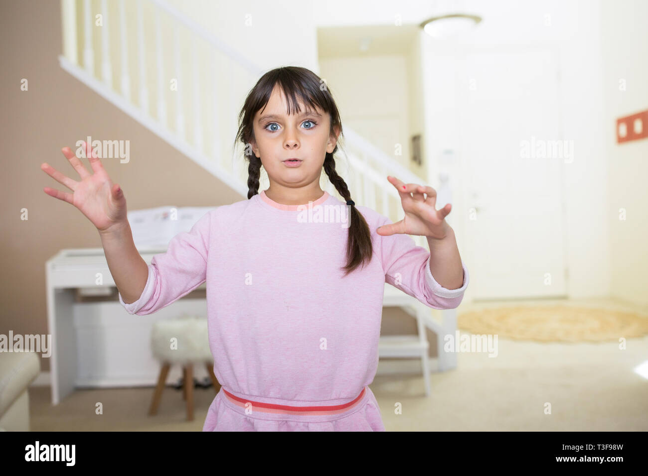 6-7 Jahre altes Mädchen hält ihre Hände hoch. Stockfoto