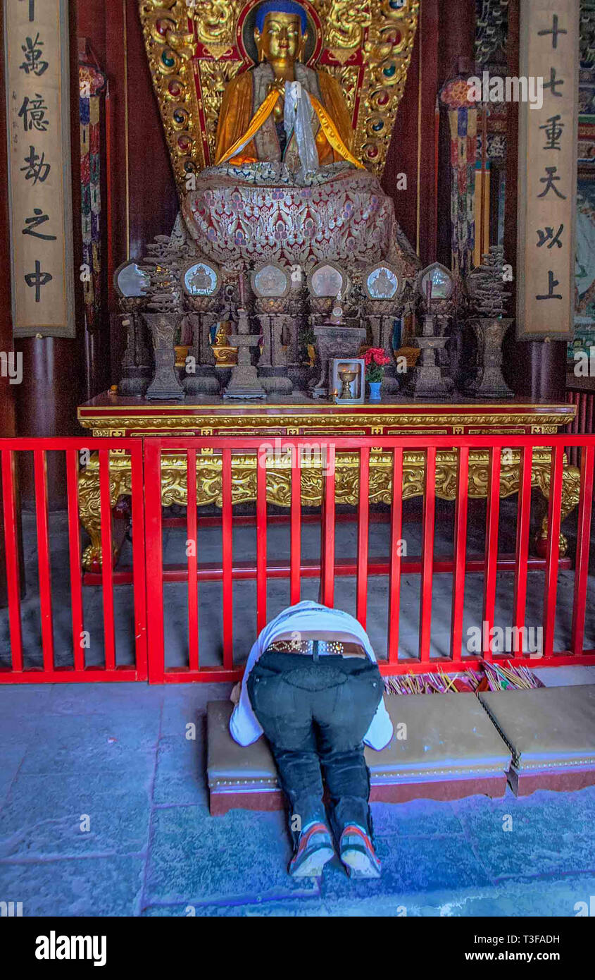 Peking, China. 17 Okt, 2006. Eine Person kniet vor einem Buddha Statue im Yonghegong Lama Tempel zu beten. Im Volksmund als Tempel des Lama bekannt, es stammt von 1694 (Qing Dynastie) und ist eine der Berühmtesten Peking Lamaseries und Tempel. Der Gelug-schule des Tibetischen Buddhismus ist es eine Kombination aus Han-chinesischen und tibetischen Stil und ein Liebling der Besucher. Credit: Arnold Drapkin/ZUMA Draht/Alamy leben Nachrichten Stockfoto