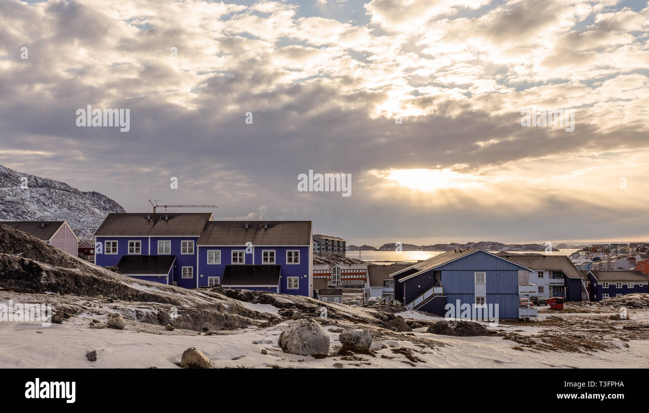 Polar Sonnenuntergang über Inuit Häuser auf den felsigen Hügeln mit Schnee, Stadt Nuuk, Grönland Stockfoto