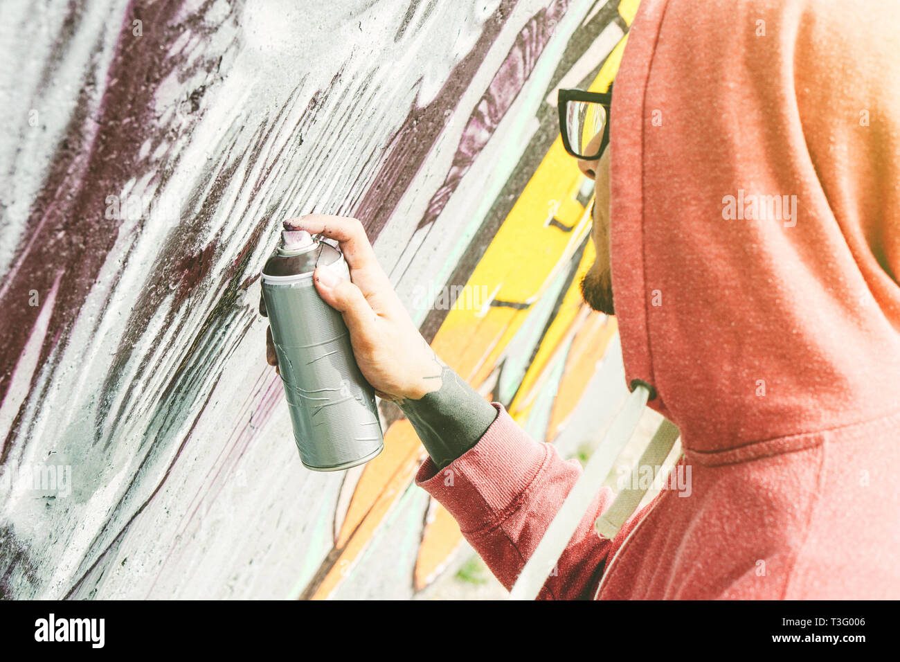 Street artist painting Graffiti mit Farbe seine Kunst an der Wand - Junge Menschen schreiben und zeichnen Murales auf der Straße spray Stockfoto