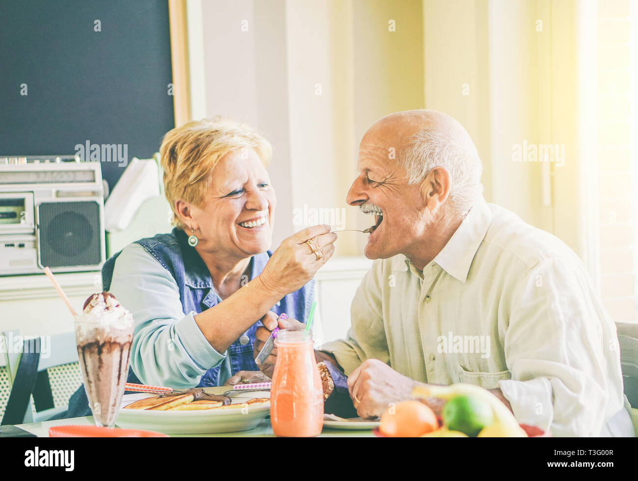 Gerne älteres Paar essen Pfannkuchen zum Frühstück in einer Bar Restaurant - alte Menschen Spaß genießen Mahlzeit am Mittag Stockfoto