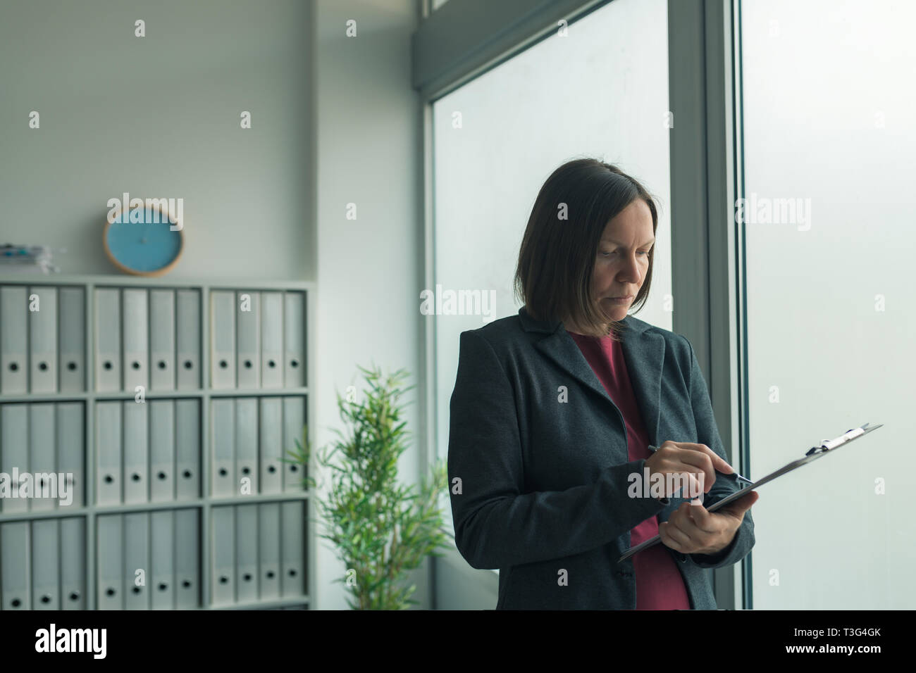 Betroffenen Geschäftsfrau lesen Business Report Papiere im Büro, finanzielle Daten Analyse und strategische Planung Konzept Stockfoto