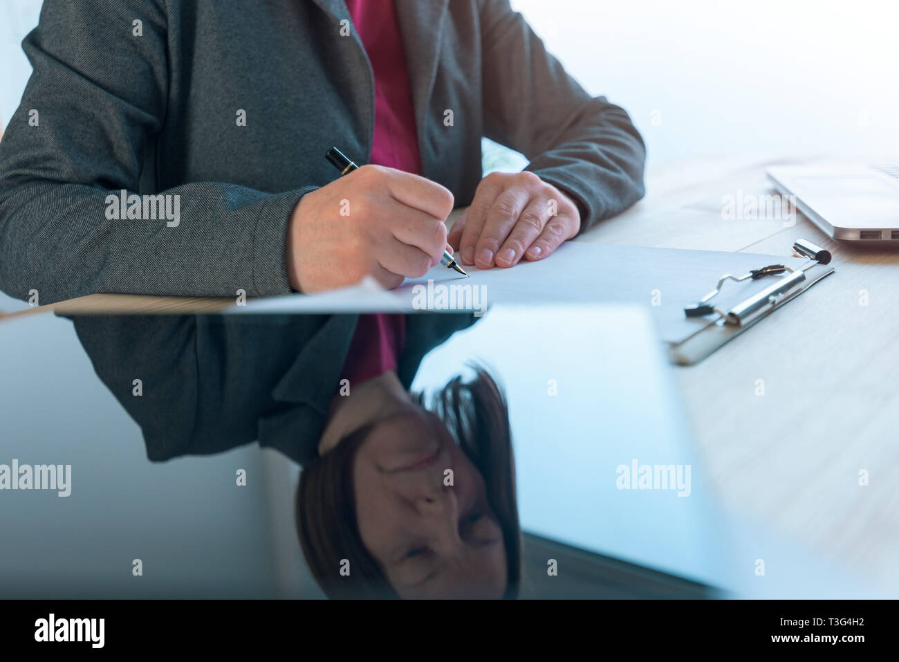 Geschäftsfrau unterzeichnen Vertrag, Reflexion über Tablet Computer im Büro Schreibtisch platziert Stockfoto