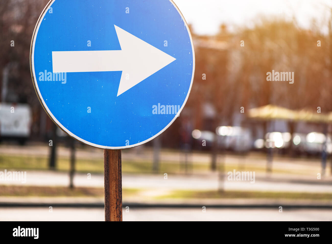In Richtung Pfeil Verkehrszeichen auf der Straße mit defokussierten Hintergrund Stockfoto