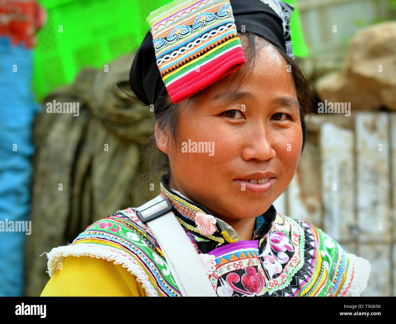 Junge Miao markt Frau (chinesische ethnische Minderheit) trägt ein buntes und authentische, traditionelle Bergvolk Kostüm. Stockfoto
