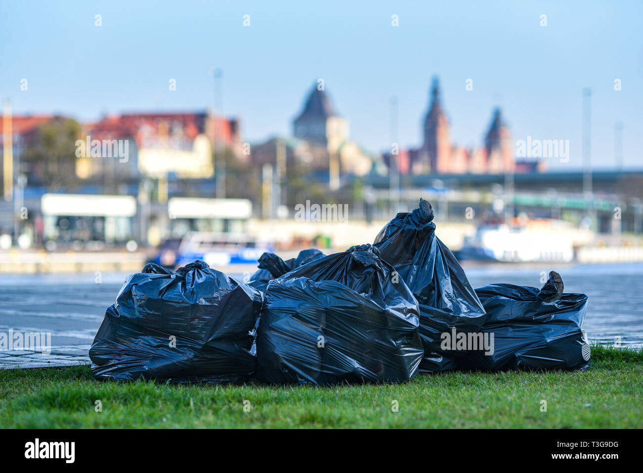 Müll in schwarzen Säcken vor dem Hintergrund der Stadt. Stockfoto