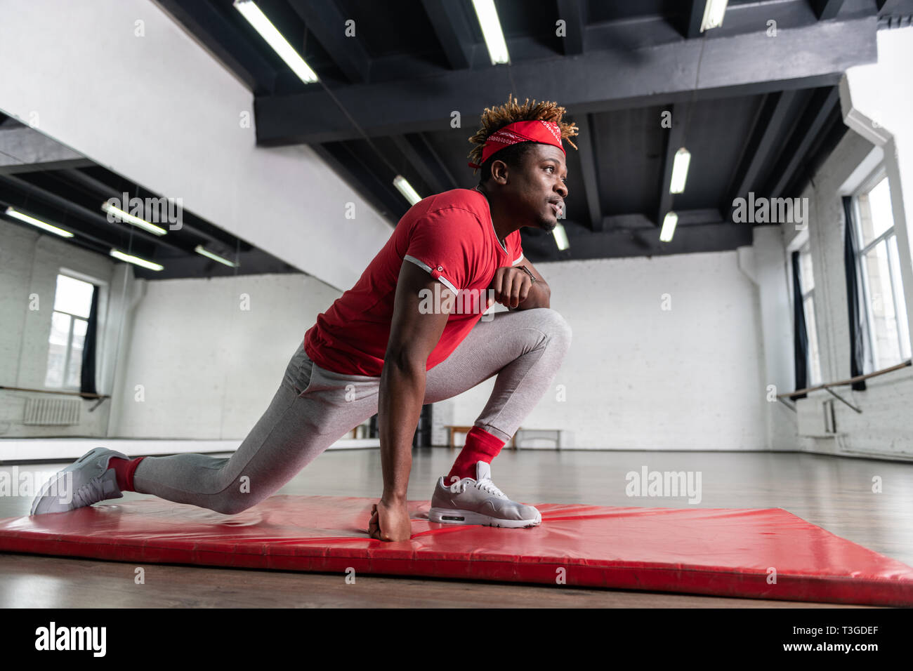 Ernsthafte aktive dunkelhäutiger Mann mit großen Muskeln Training im Studio Stockfoto
