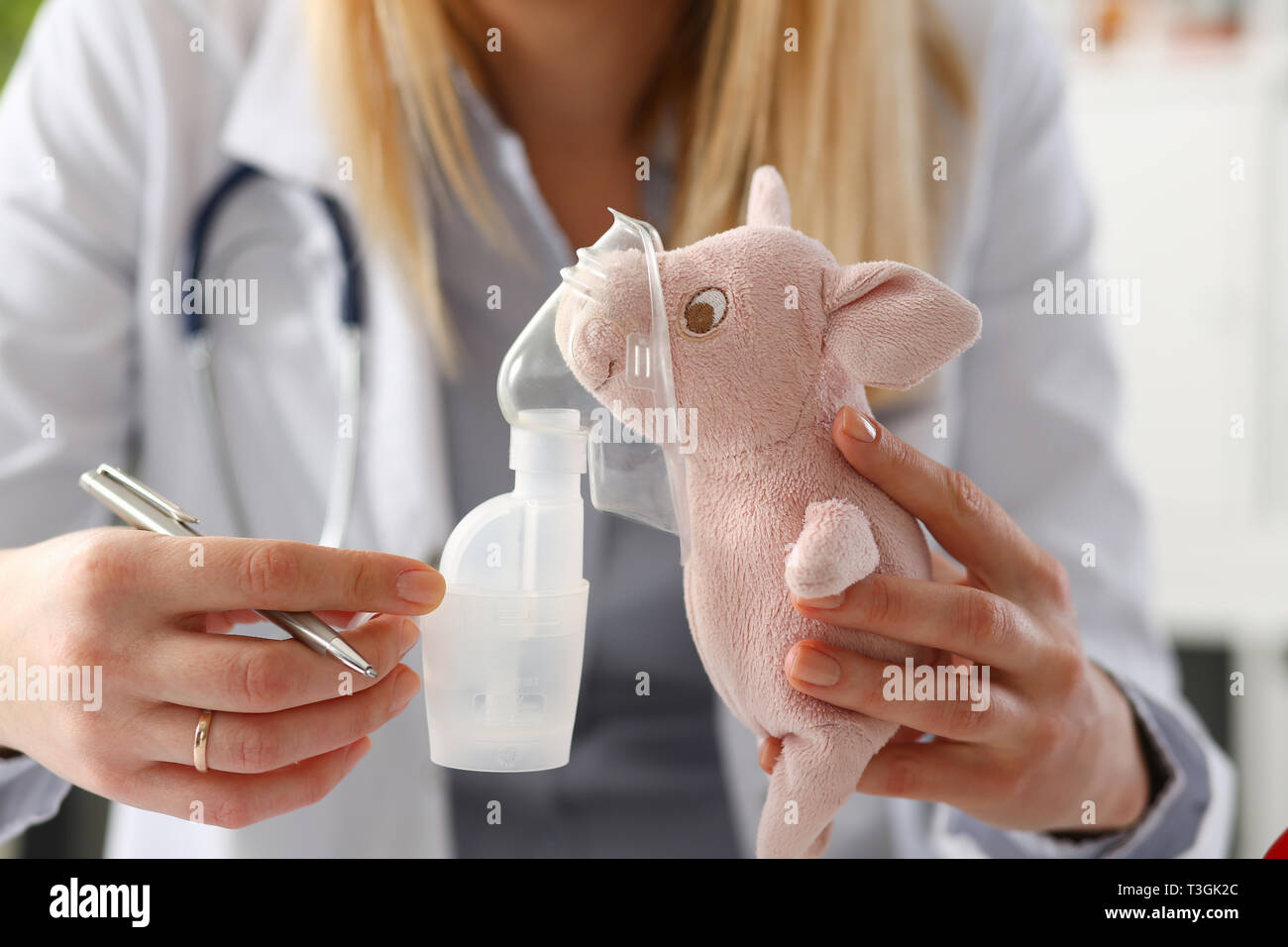 Doktor spielen mit kleinen Patienten geben Inhalator zu Spielzeug Stockfoto