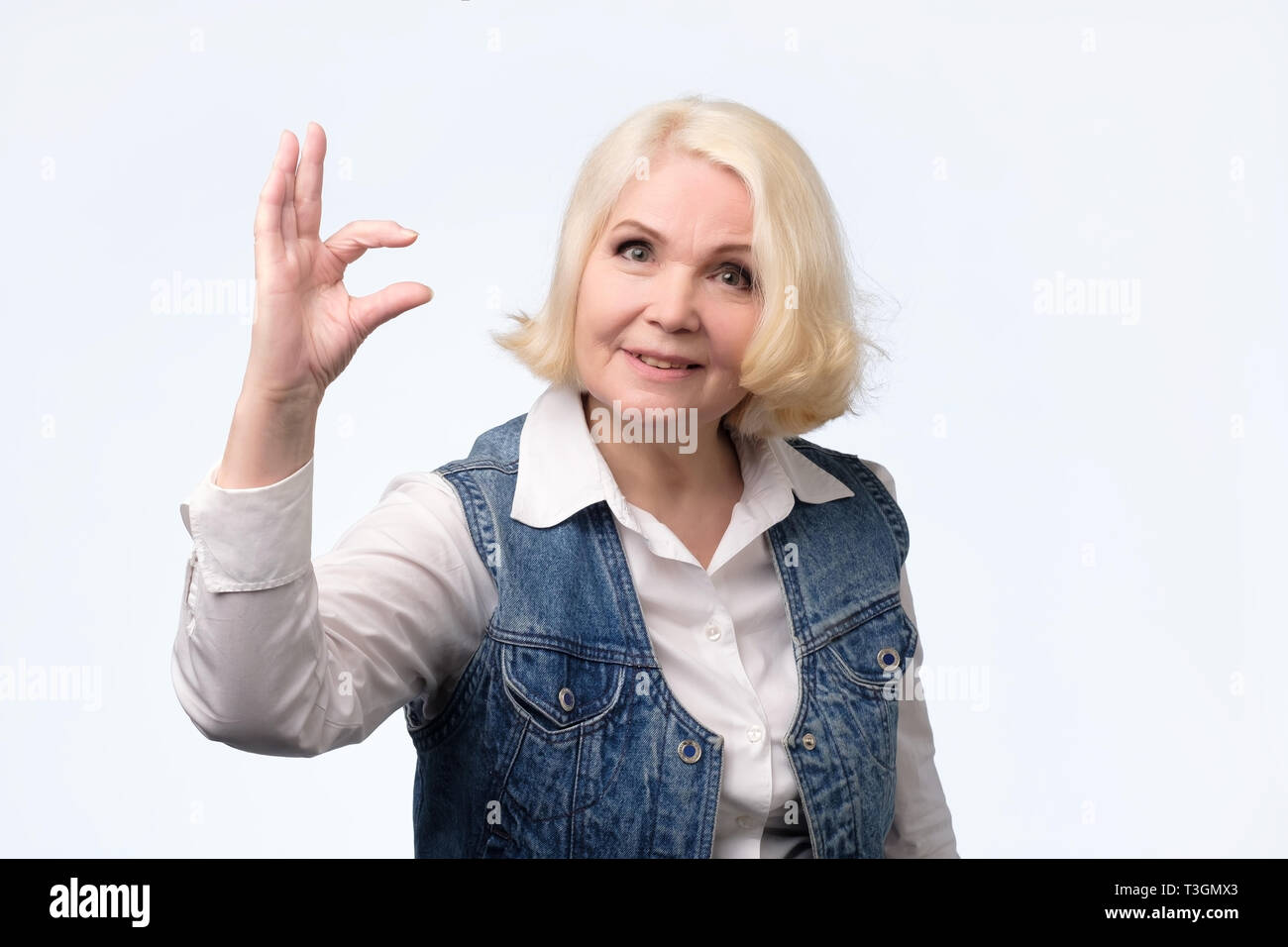 Ältere Frau, kleine Zeichen mit den Fingern Stockfoto
