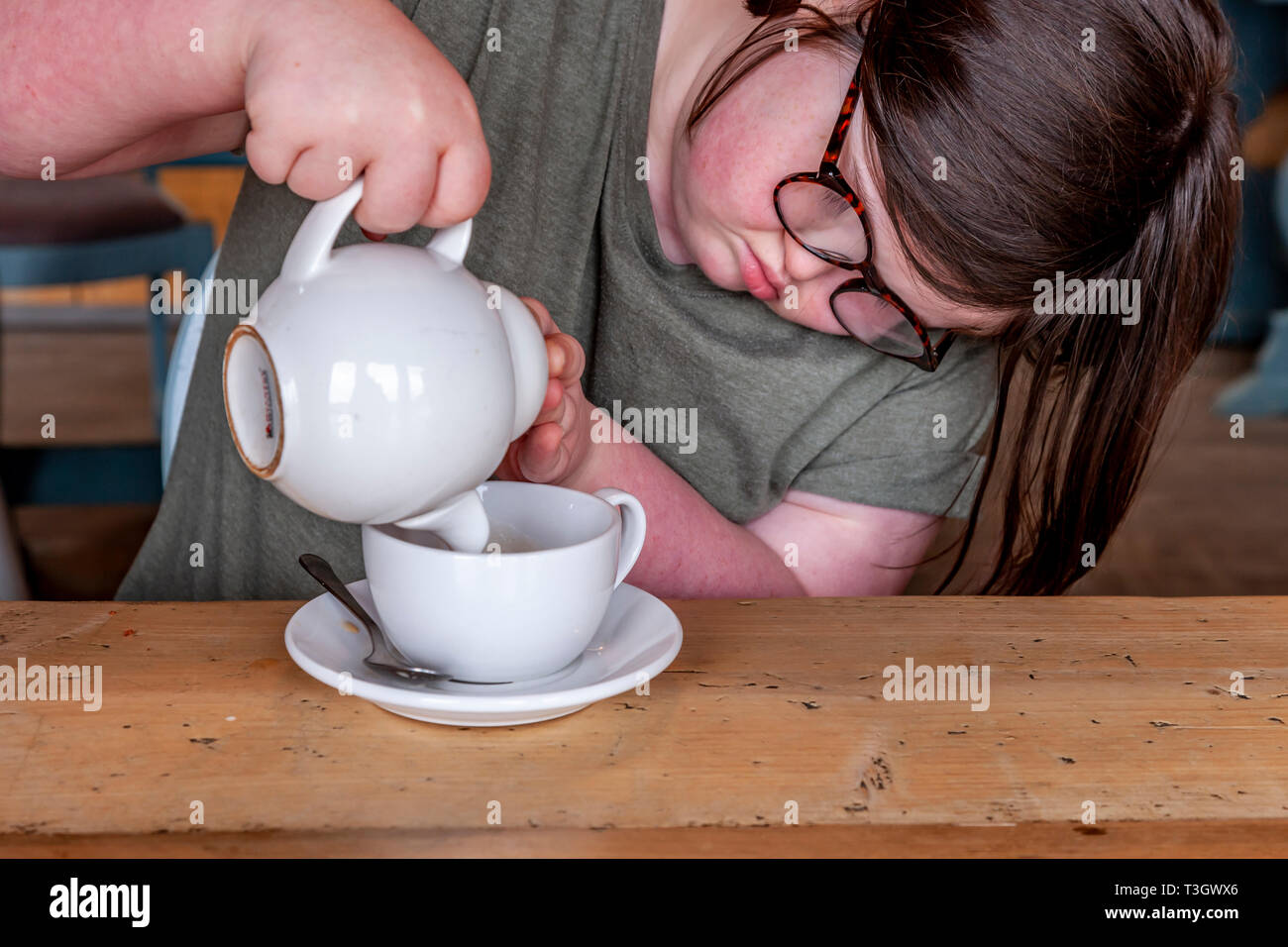 Junges Mädchen mit Down-syndrom lernen Life Skills haben eine Tasse Tee. Stockfoto