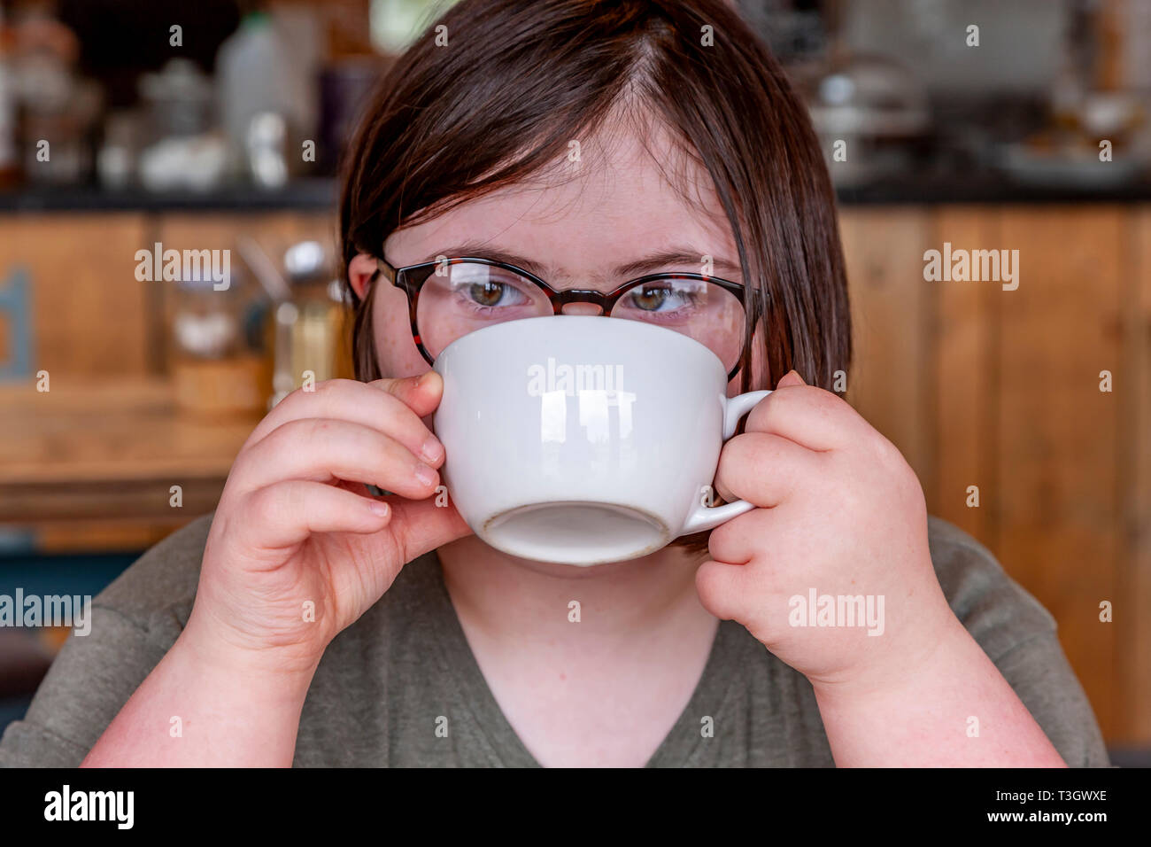 Junges Mädchen mit Down-syndrom lernen Life Skills haben eine Tasse Tee. Stockfoto
