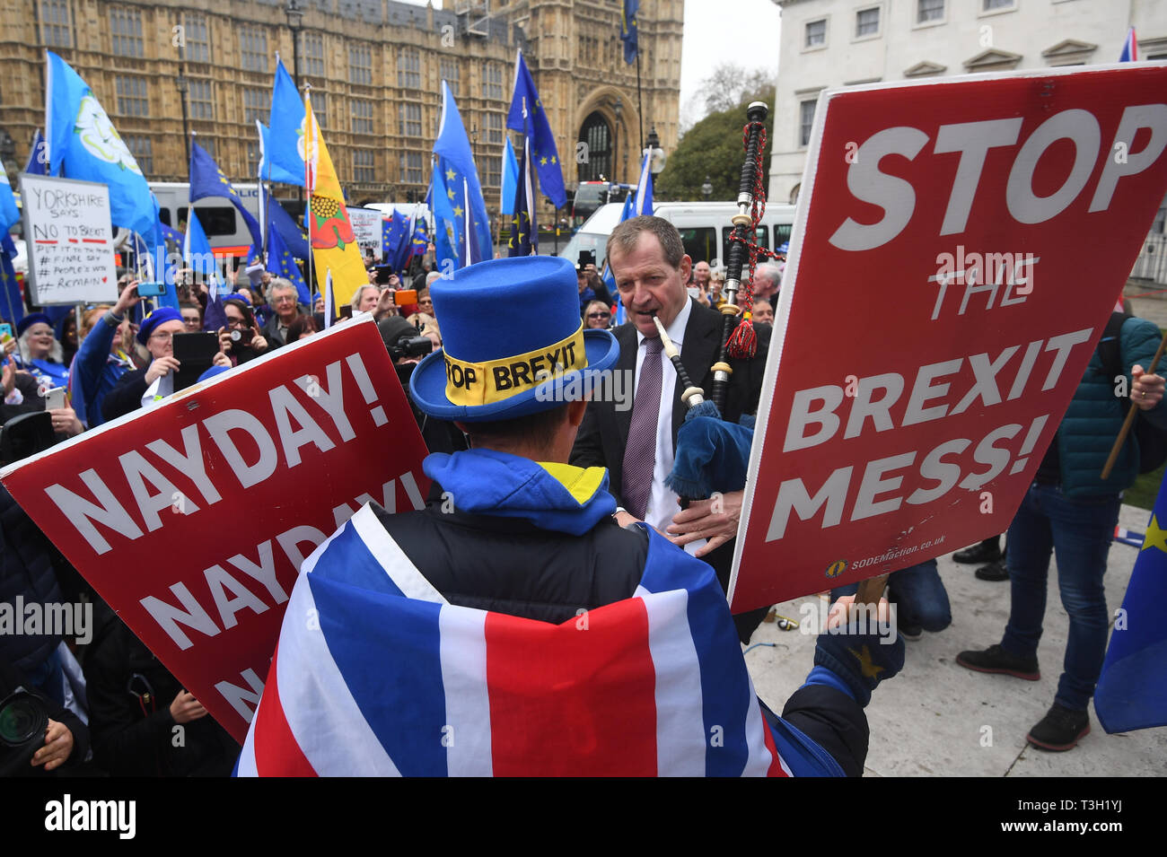 Alastair Campbell spielt Dudelsack durch Demonstranten außerhalb des Houses of Parliament in Westminster umgeben. Stockfoto