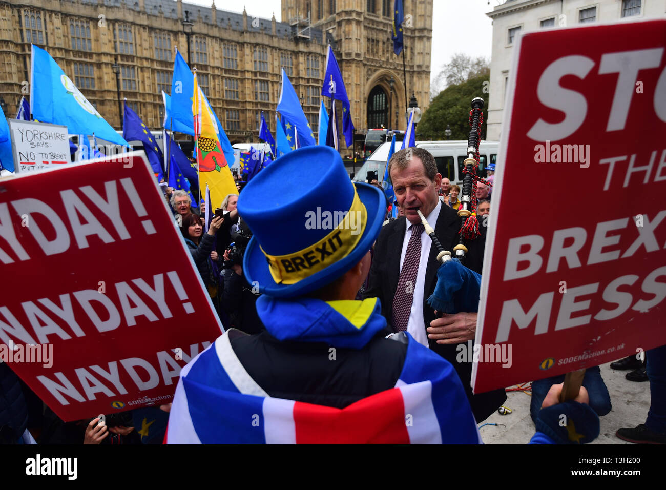 Alastair Campbell spielt Dudelsack durch Demonstranten außerhalb des Houses of Parliament in Westminster umgeben. Stockfoto