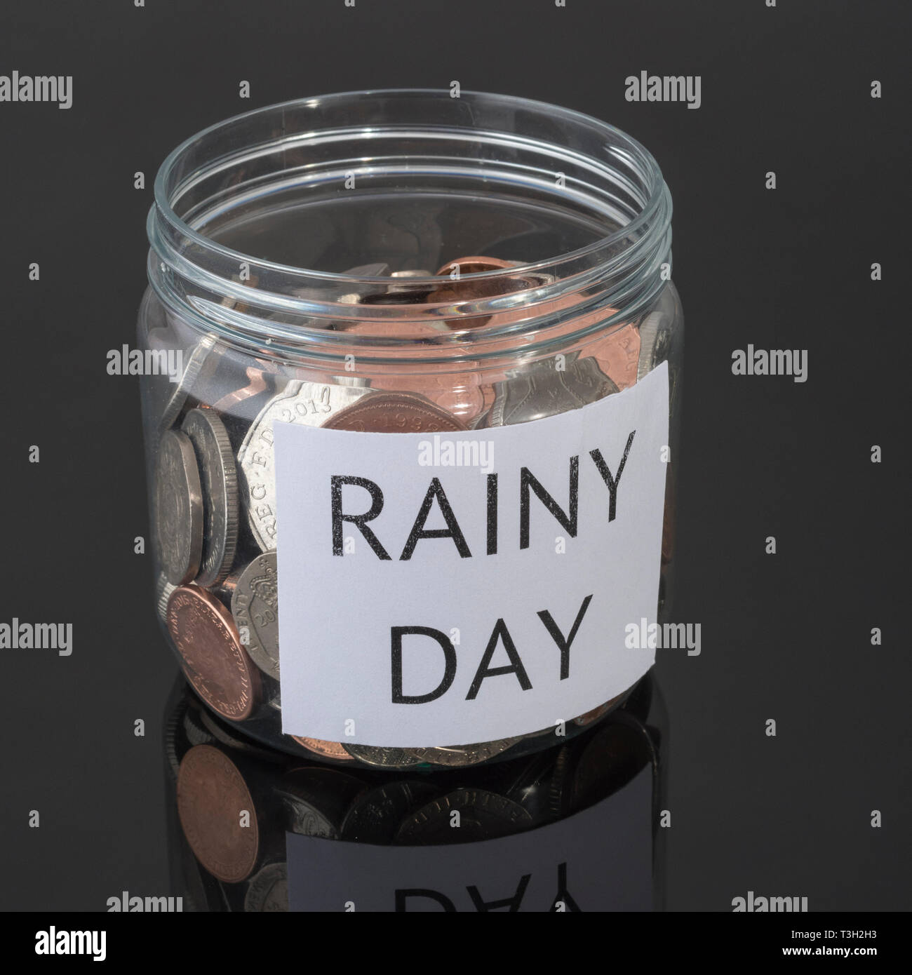 Plastik Topf mit Großbritannien Münzen. Metapher persönlichen Ersparnissen, regnerischer Tag sparen, Altersvorsorge, Vorsorge, für die Zeit nach der Pensionierung zu sparen. Stockfoto