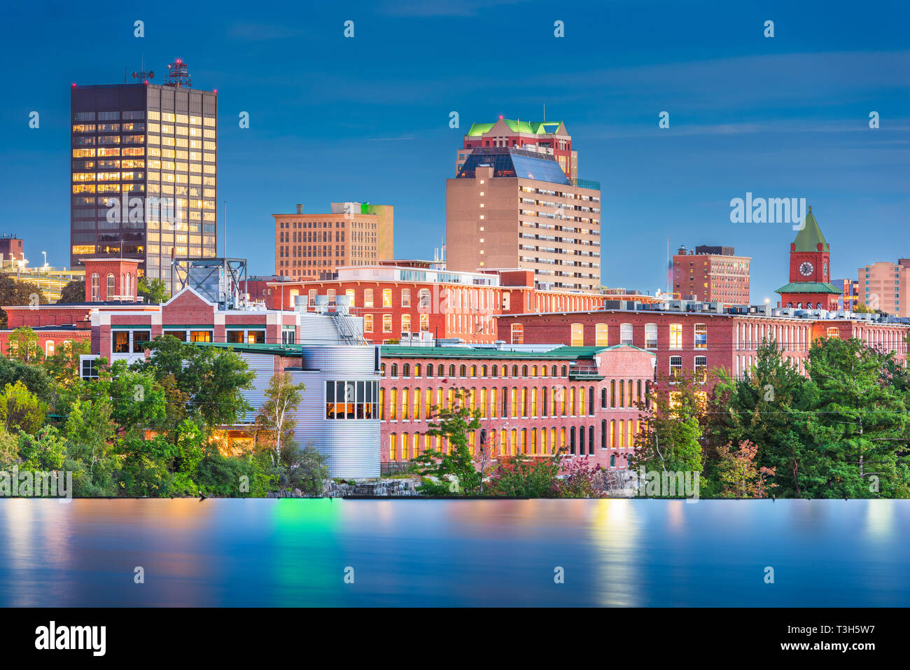 Manchester, New Hampshire, USA Skyline am Merrimack River in der Abenddämmerung. Stockfoto