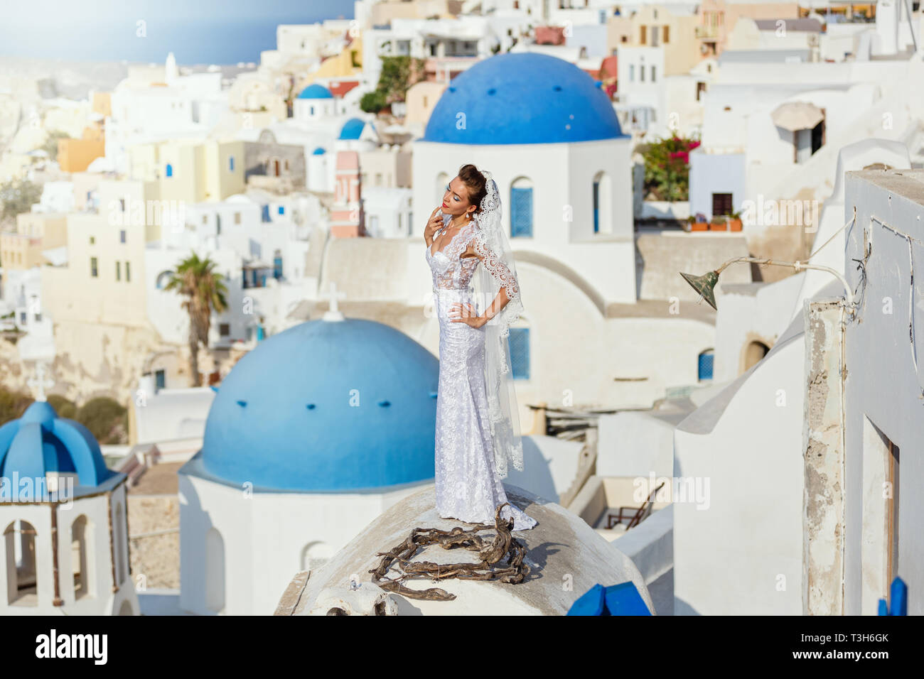 Junge Braut auf dem Hintergrund von Meer und Architektur, Insel Santorini, Griechenland Stockfoto