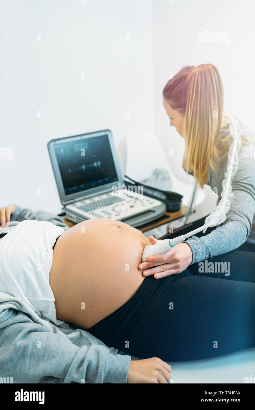 Arzt einen Ultraschall für schwangere Frau Scan Stockfoto