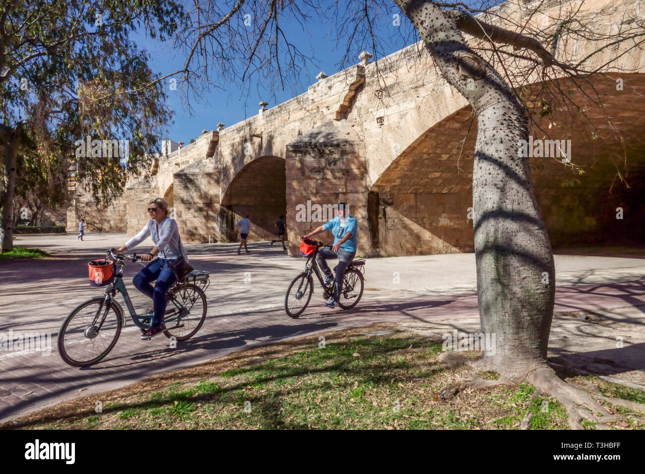 Radfahrer unter der Brücke Pont del Serrans Turia-Gärten Valencia Spanien Fahrradstadt Europa Stadtpark Menschen radeln Valencia Turia-Gärten Radfahren Valencia Stockfoto
