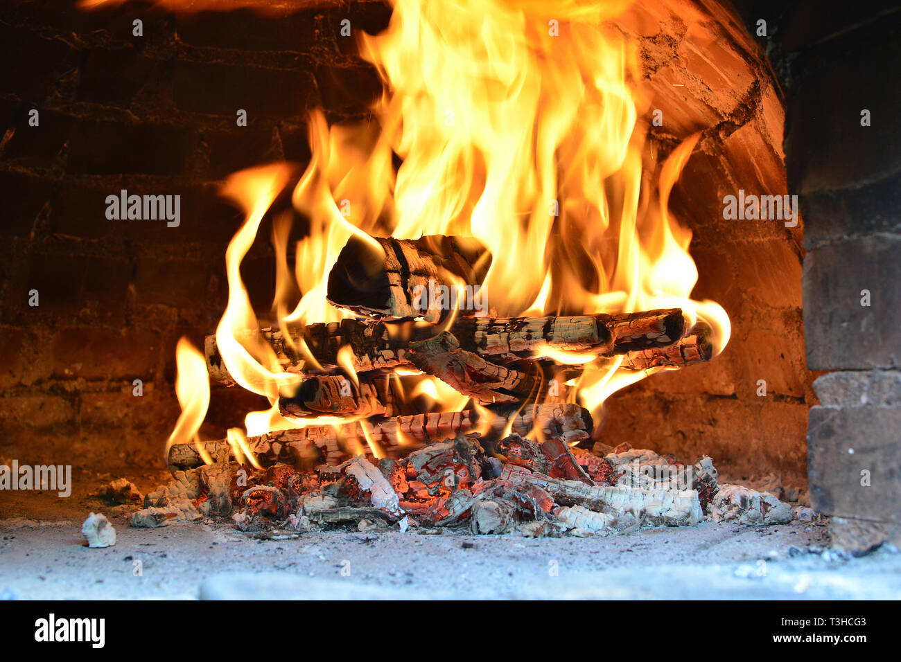 Große Feuer in Pizza Ofen, Heizung Ziegel und Gewölbe der Pizza Backofen während der Vorbereitung für neue Arbeitstag des Italienischen Restaurant Stockfoto
