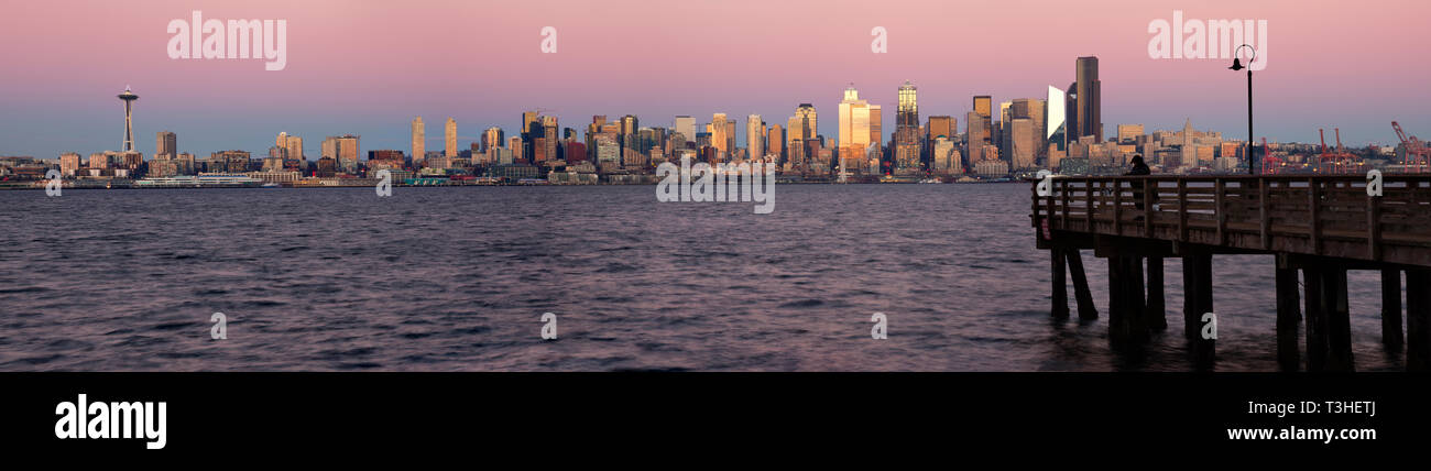 WA16108-00...WASHINGTON - die untergehende Sonne sorgt bei Sonnenuntergang im Seacrest Park an den Ufern der Elliott Bay, 2018, für ein Leuchten auf den Hochhäusern in Seattle. Stockfoto