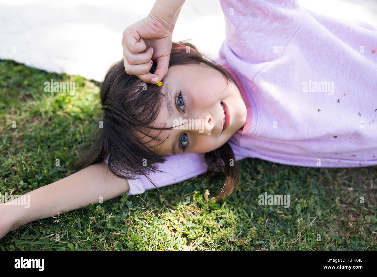 6-7 Jahre alten Mädchen mit auf dem Gras und schauen in die Kamera. Stockfoto