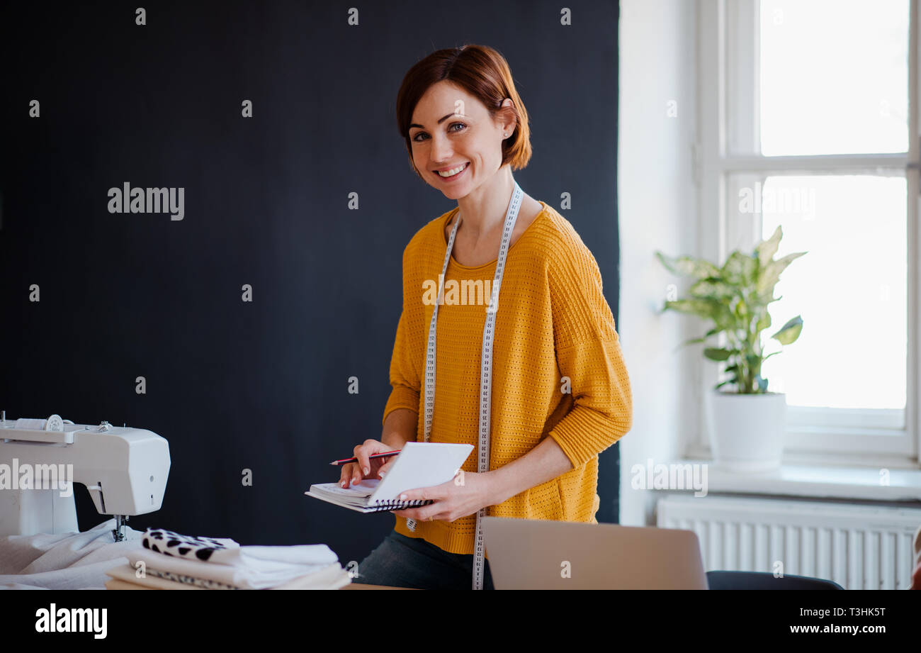 Junge kreative Frau, die in einem Studio, schreiben. Ein Startup zu schneidern. Stockfoto