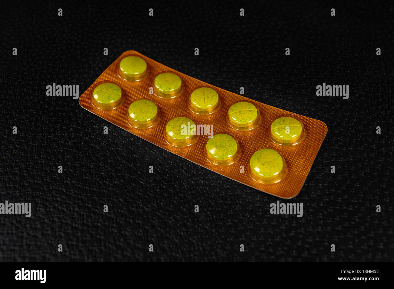 10 Tabletten Blister mit 10 Tabletten auf eine schwarze Fläche Stockfoto
