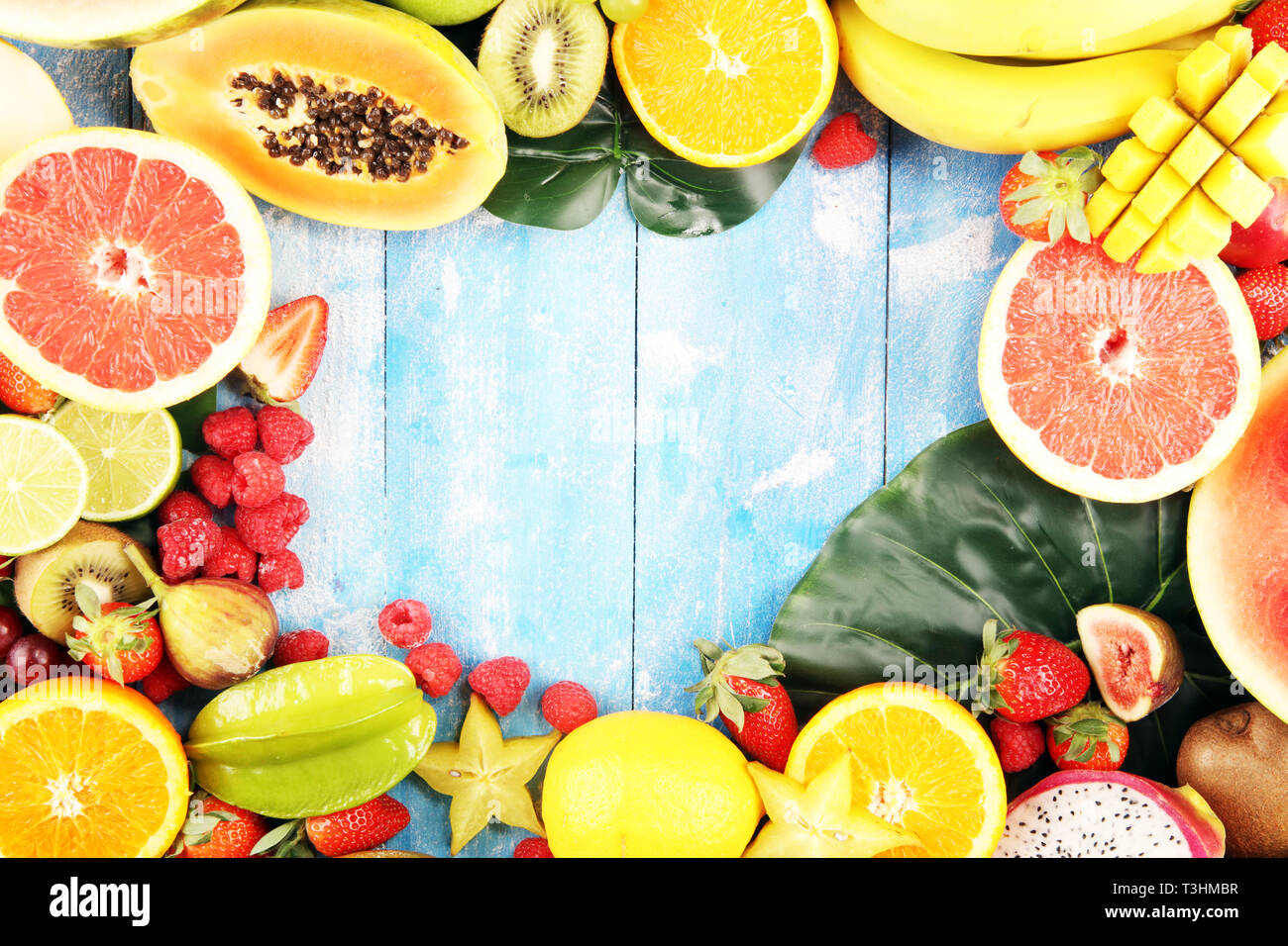 Tropische Früchte Hintergrund, viele bunte reife tropische Früchte auf hölzernen Tisch Stockfoto