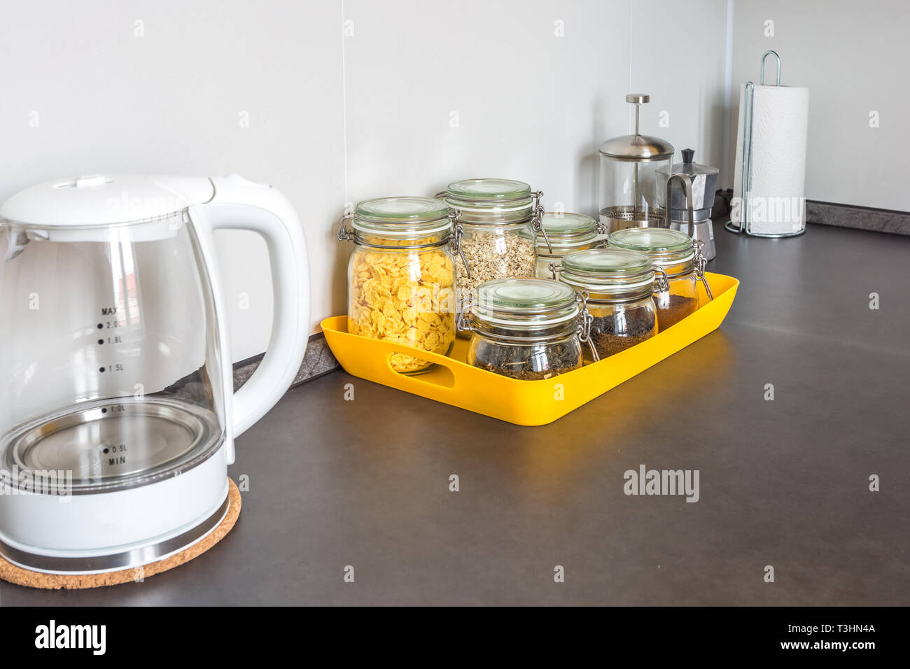 Glas stilvolle vintage Gläser mit verschiedenen Speisen und Teekanne im Inneren der modernen Küche im Loft Wohnung Wohnung im minimalistischen Stil mit Gelb c Stockfoto