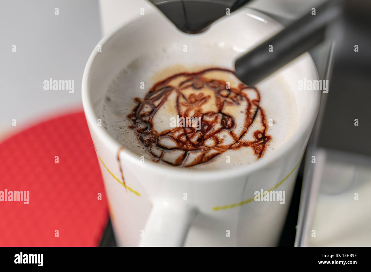 Die Cappuccino. Blick auf Espresso gießen aus der Kaffeemaschine. Cappuccino hat die wichtigsten Bestandteile sind Espresso und Milch. Unscharfer Hintergrund Stockfoto
