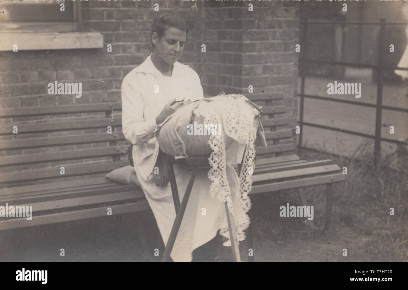 Jahrgang fotografische Postkarte zeigt eine Dame saß im Freien Nähen oder Nähen Spitze. Stockfoto