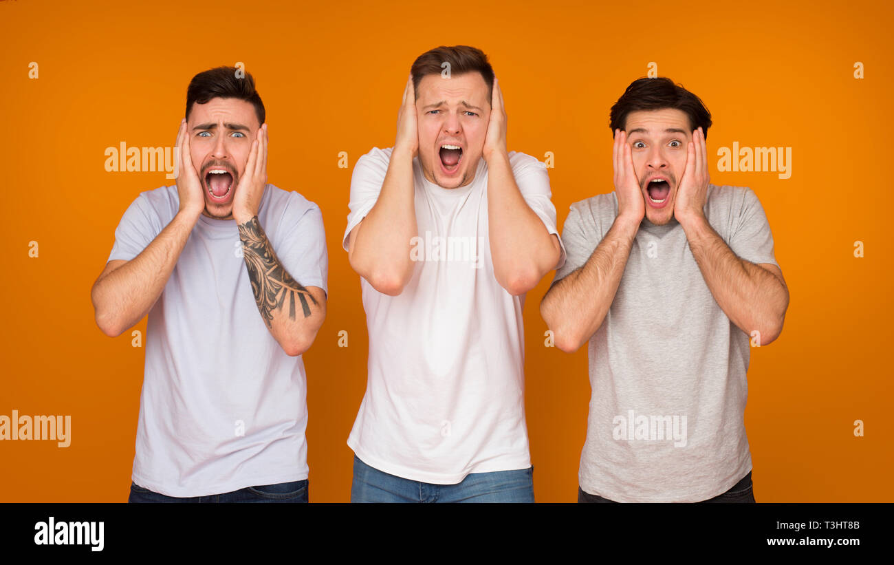 Männer mit offenen Mund über orange Hintergrund Schockiert Stockfoto