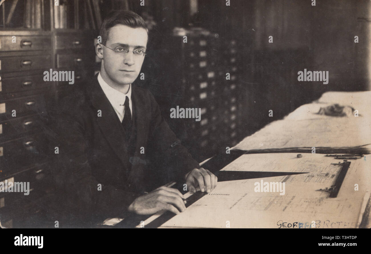 Jahrgang fotografische Postkarte zeigt einen geeigneten Mann saß in seinem Büro. Aus technischen Zeichnungen auf seinem Schreibtisch, Er scheint ein Zeichner zu werden. Stockfoto