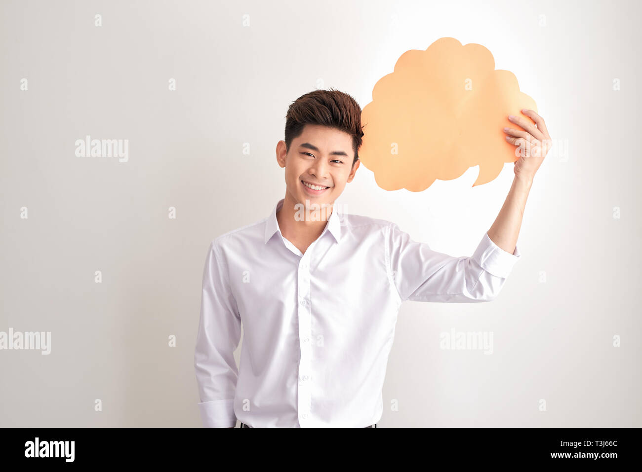 Tolle Idee: Laughing Man Holding weiße Leere Sprechblase mit Platz für Text, während Nachdenken auf grauem Hintergrund. Stockfoto