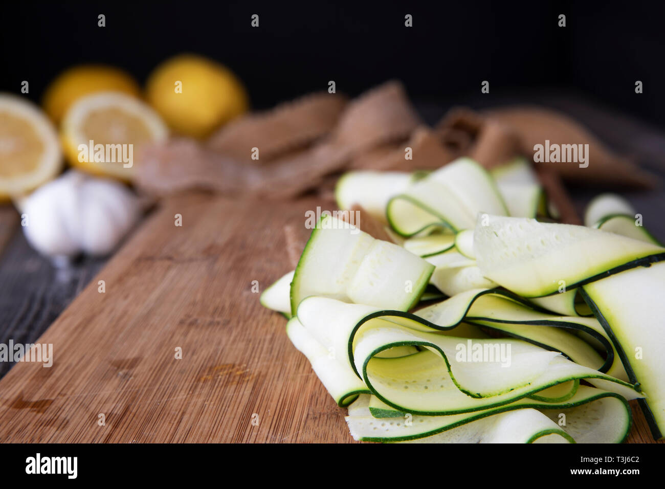 Frische Zucchini in Scheiben geschnitten in die Bänder und sitzen auf Holz Schneidebrett. Stockfoto
