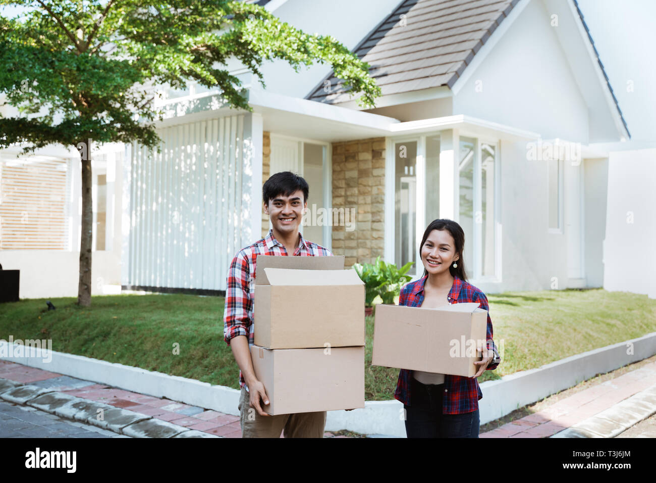 Paar Umzug in Ihr neues Haus holding Karton Stockfoto