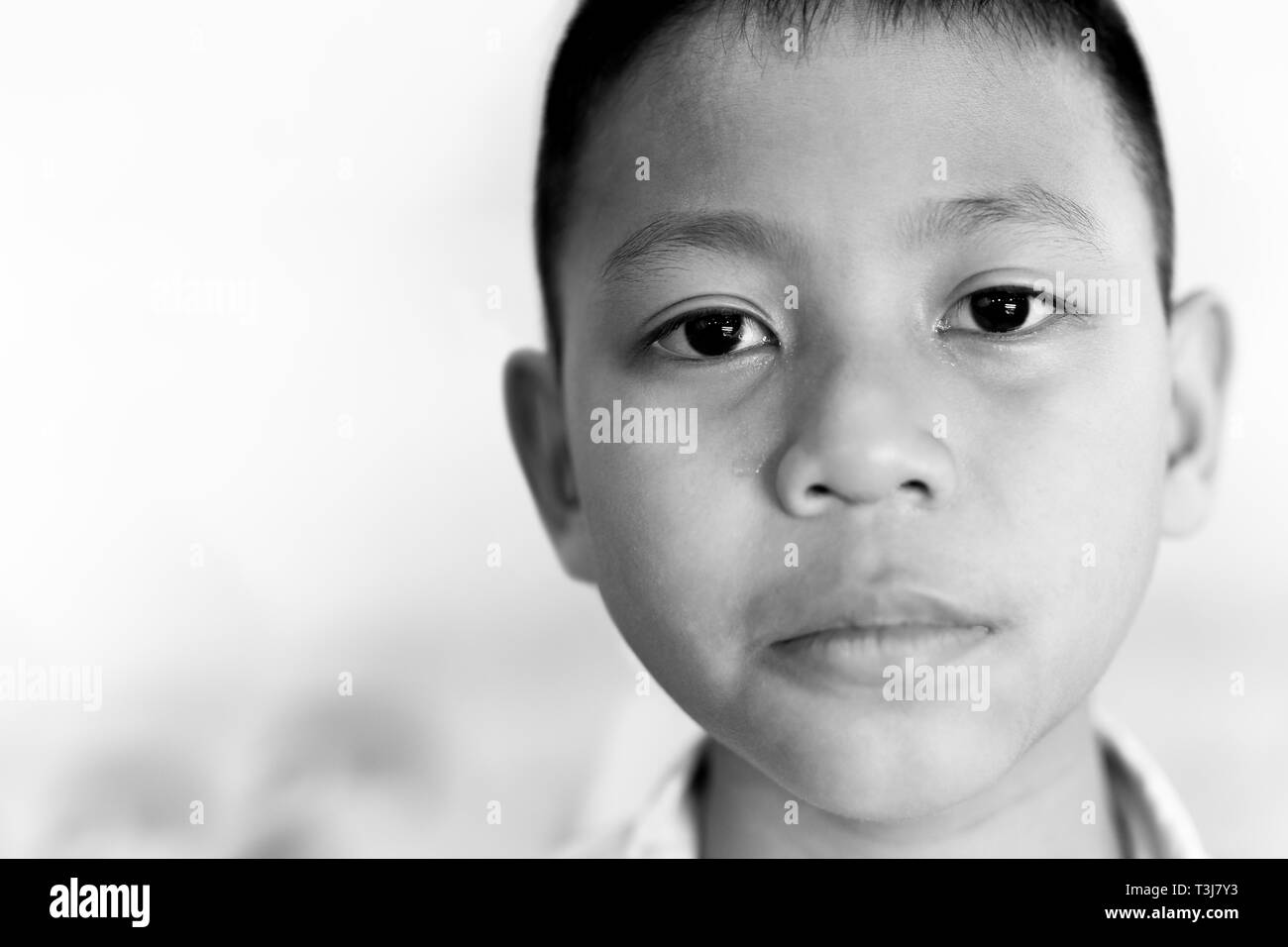 Portrait von asiatischen Jungen weinen mit Abrisskante auf seinem Gesicht in Schwarz und Weiß. Stockfoto