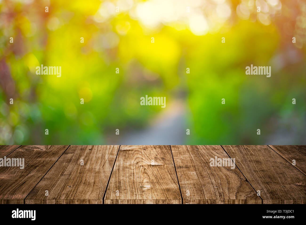 Blur, grünen Garten mit hölzernen Tischplatte Vordergrund für Werbung montage Hintergrund. Stockfoto