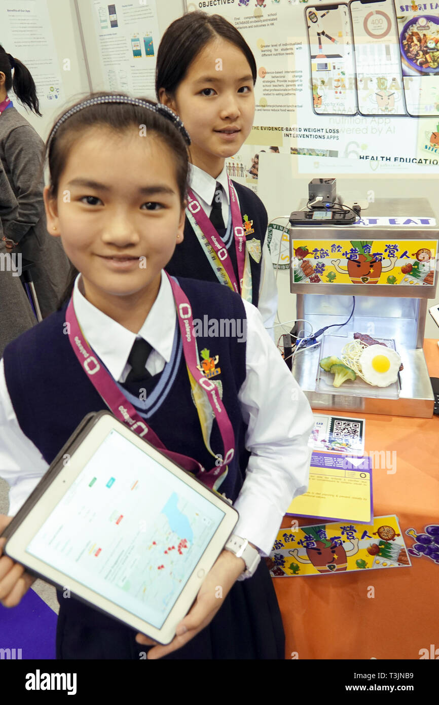 Genf, Schweiz. 10 Apr, 2019. Auf dem Genfer Erfindermesse, zwei Schülerinnen aus Hong Kong präsentieren eine App, die Sie halfen zu entwickeln. Eltern erhalten ein Foto der Verpackung Ihres Kindes Pause direkt an Ihr Smartphone gesendet. Nach der Pause. So können Sie sehen, was die Kinder nicht in der Pause essen. Die App zeigt, welche Zutaten fehlen, empfiehlt etwas für das Abendessen und zeigt, wo Sie sie kaufen können. (Dpa howers auf Abruf - faire Erfindermesse in Genf zeigt nützliche Dinge im Alltag") Credit: Christiane Oelrich/dpa/Alamy leben Nachrichten Stockfoto