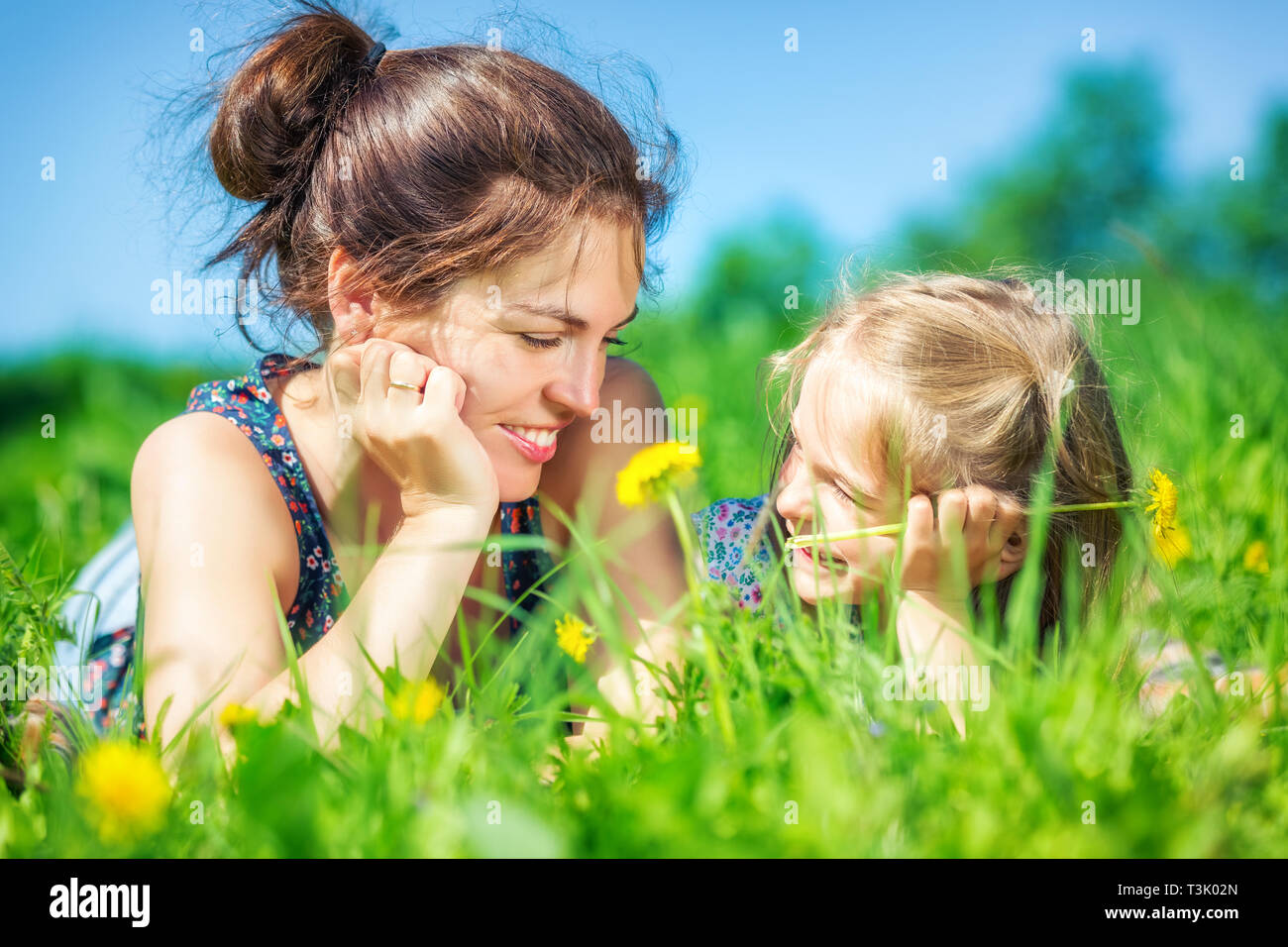 Junge Frau und ihre Tochter auf grüner Sommer Gras Stockfoto