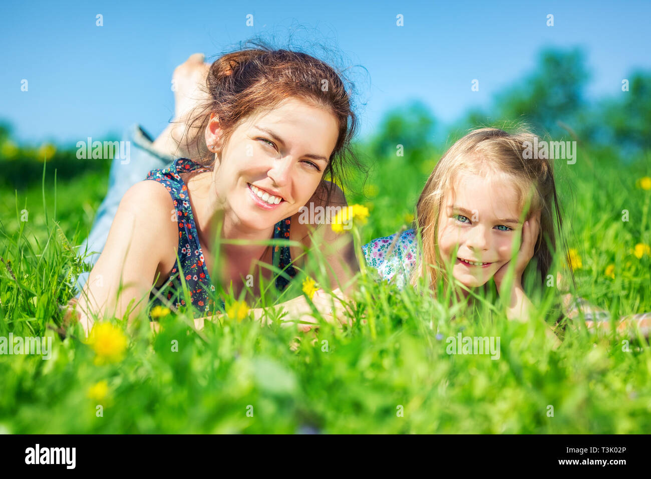 Junge Frau und ihre Tochter auf grüner Sommer Gras Stockfoto