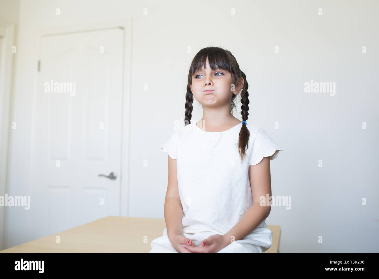6-7 Jahre alten Mädchen ist langweilig zu warten. Sie hat eine Haltung. Stockfoto