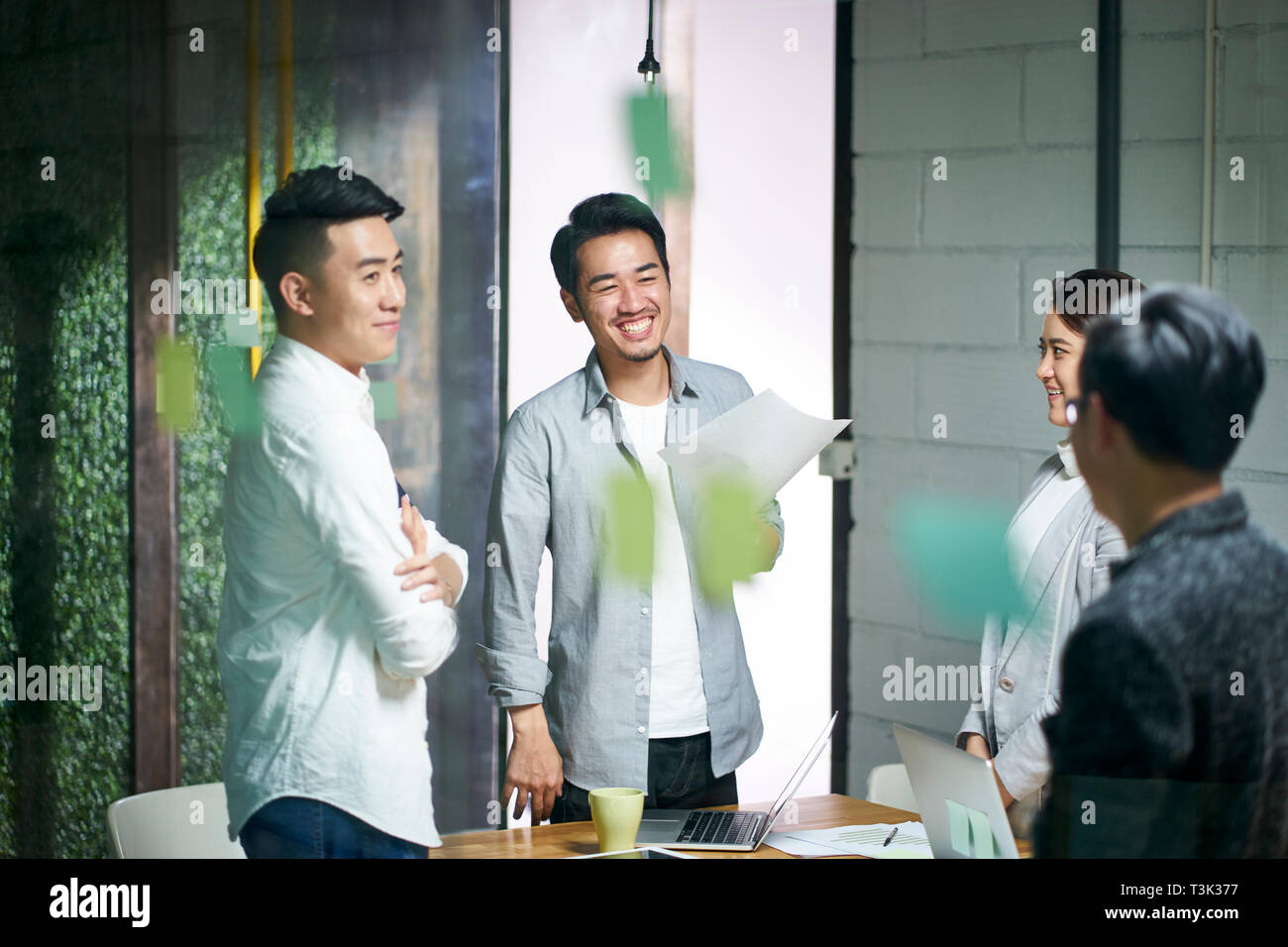 Glückliche junge asiatische Unternehmer Team plaudern während der Sitzung im Büro. Stockfoto