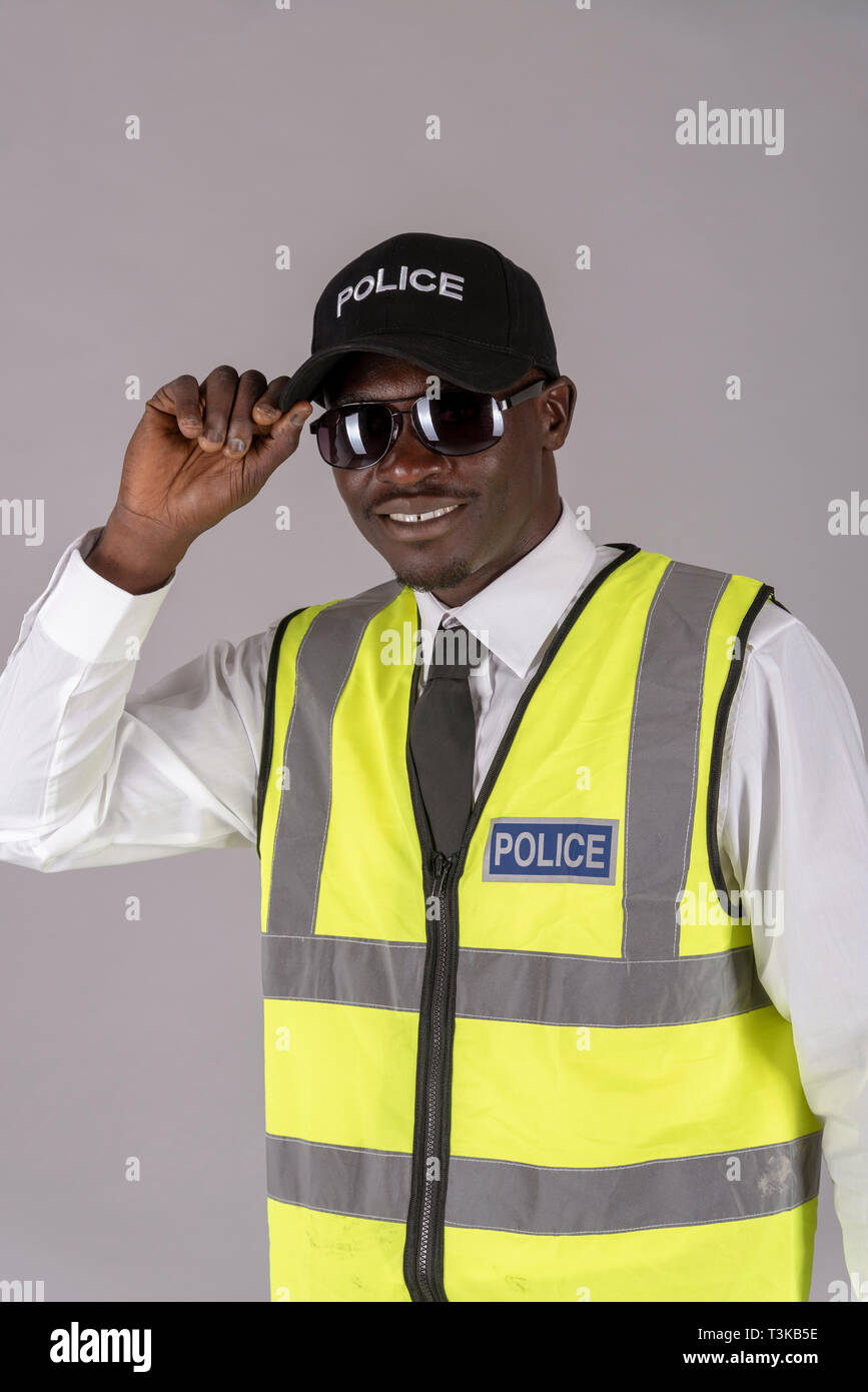 Porträt eines lächelnden Polizisten in Uniform und hält ein paar dunkle Brille zum Schutz der Augen. Stockfoto