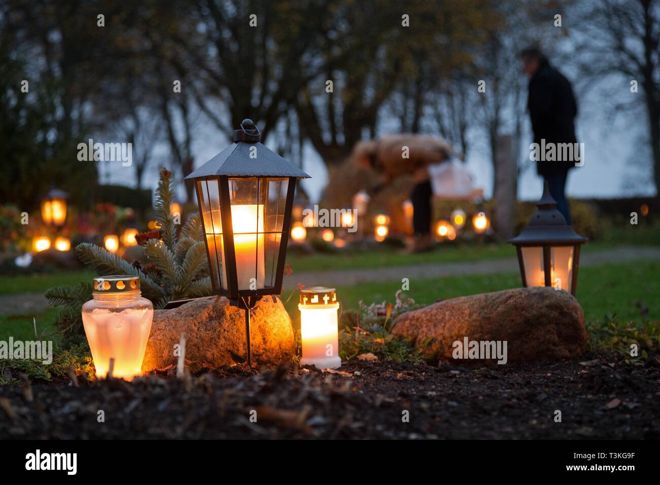 Brennende Kerzen auf den Gräbern auf dem Friedhof während der Halloween Tag. Stockfoto