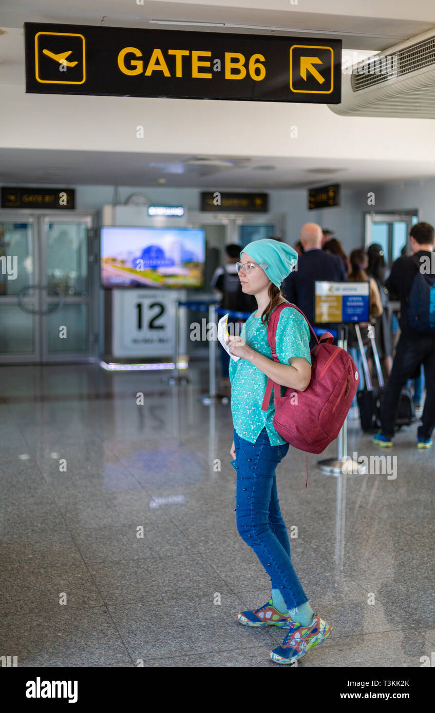 Asiatischen Teenager mit einem -Smartphone Flug am internationalen Flughafen zu überprüfen an den Wochenenden zu reisen Stockfoto