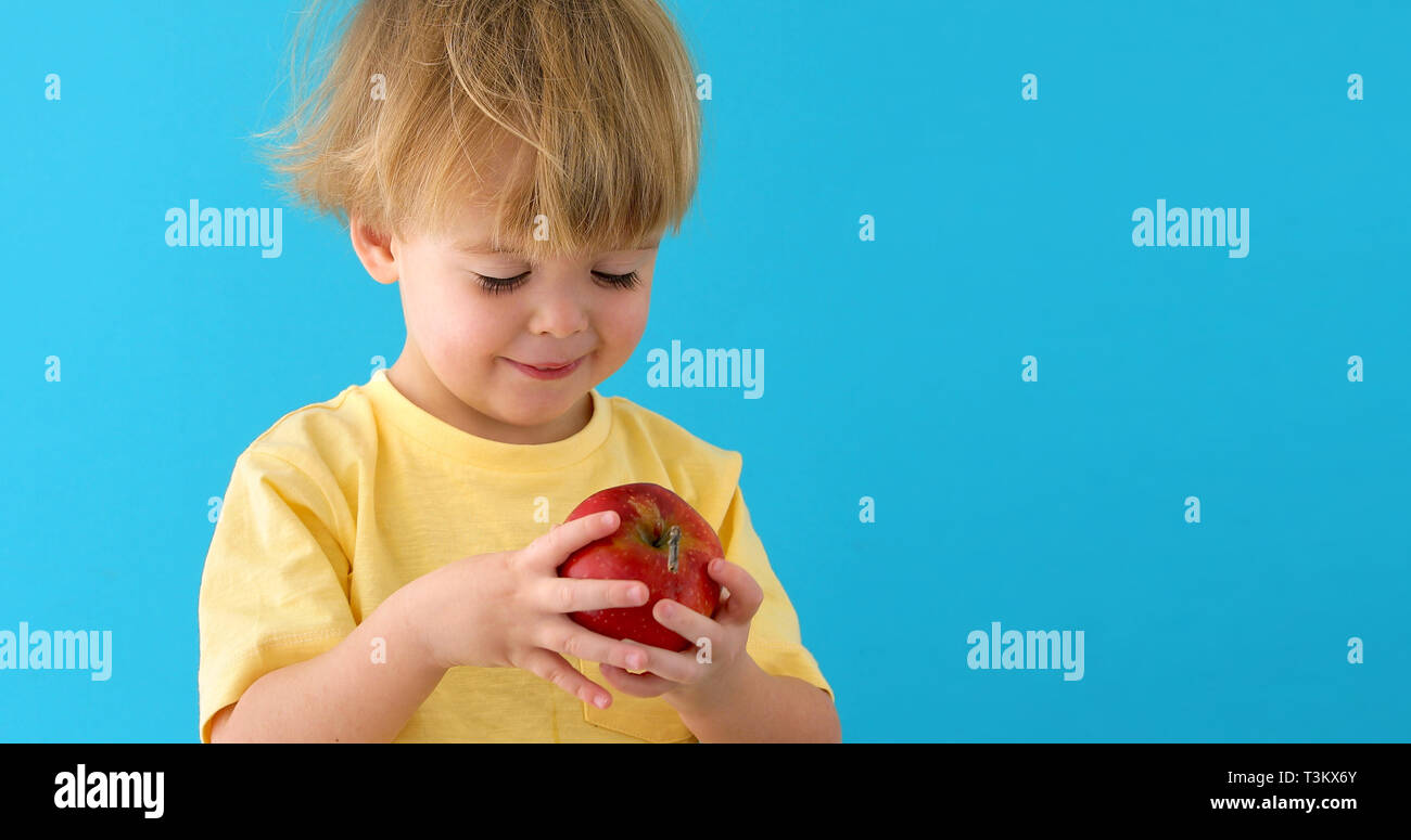 Kind mit Red Delicious Apple auf Blau backgroun Stockfoto